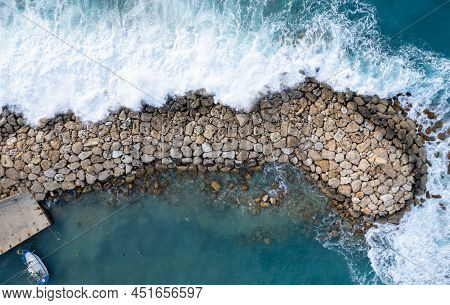 Aerial Drone Of Stormy Windy Waves Hitting With Power The Breakwater. Extreme Weather At Sea. Peyia,