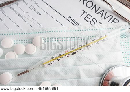 Close Up Of Thermometer, Face Mask And White Pills