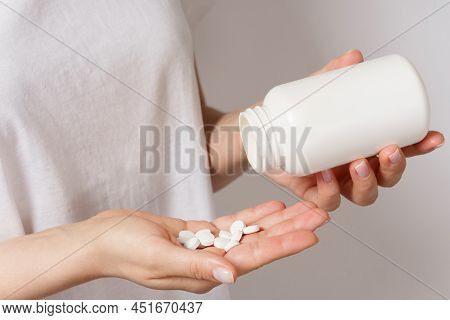 Woman Is Holding Jar With White Pills