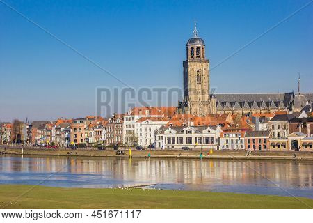 Deventer, Netherlands - March 03, 2022: Old Houses And Historic Lebuinus Church Tower At The River I