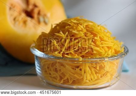 Shredded Pumpkin In A Glass Bowl. Shot Along With A Slice Of Pumpkin.