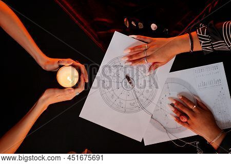 Top View Of Female Fortune Teller Reading Astrology Chart For Young Woman Visiting At Spiritual Sean
