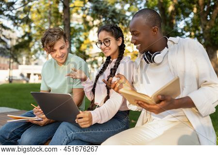Happy Diverse Students Studying Together In Park, Preparing For Test And Looking At Laptop Screen, S