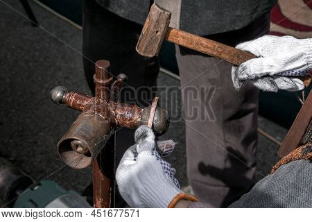 Master With A Hammer Performs Stamping Or Engraving Of A Decorative Pattern On A Metal Plate