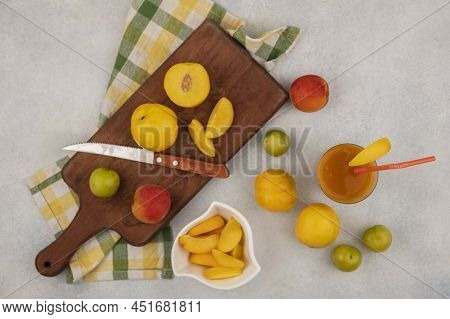 Top View Of Fresh Yellow Peaches On A Wooden Kitchen Board With Knife With Chopped Slices Of Peach O