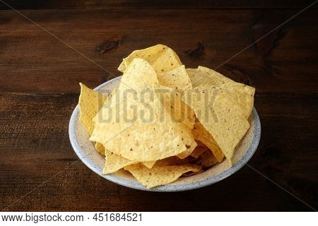 Closeup Bowl Of Nacho Chips On Wood Kitchen Table