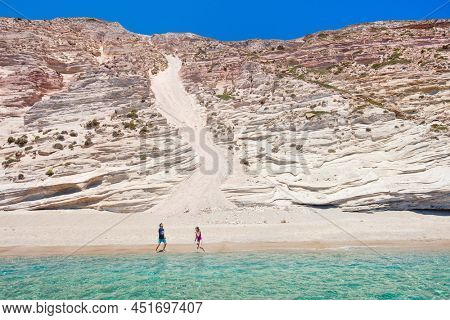 Family of father and his teenage daughter enjoying secluded Gerakas beach accessible only by boat on Greek island of Milos
