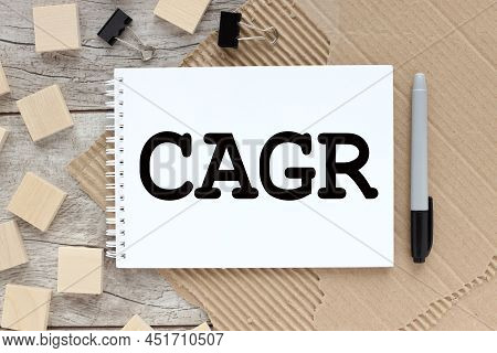 Cagr Compound Annual Growth Rate Symbol. Text On An Open Notebook On The Table Wooden Cubes Near The