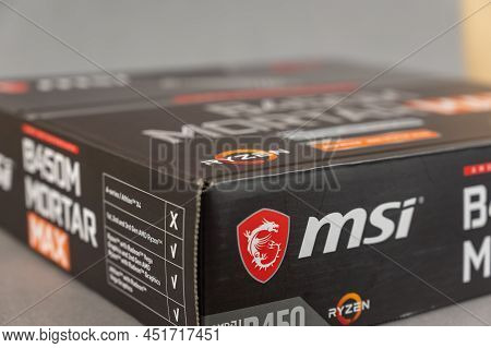 Msi B450 Mortal Max Motherboard Against A Gray Background. Black Box With The New Computer Hardware.