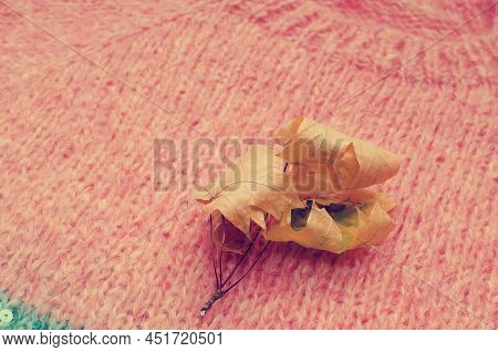Yellow Autumn Leaf On The Background Of A Knitted Sweater. Cozy Warm Autumn Concept.