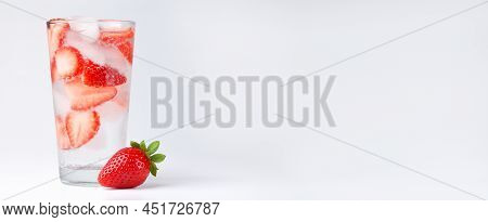 A Glass Of Cold Strawberry Water With Ice, One Strawberry On The Side, Light Background, Side View, 