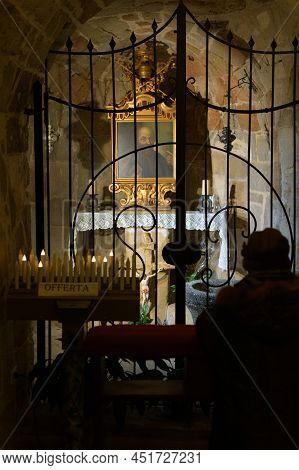 San Pietro, Italy - Dicembre, 26, 2021 A Silhouette Of A Person Praying In A Church In The Shade Aga