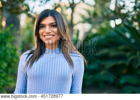 Beautiful hispanic woman smiling confient at the park