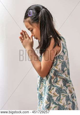 Portrait Asian Child Girl Is Greeting In Thailand Traditional Style That Called Sawatdee. Asian Gree