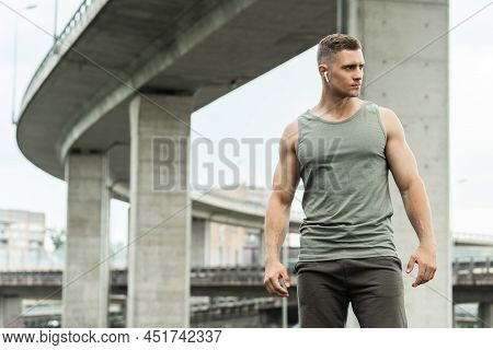 Handsome Man With An Wirless Earbuds. Listening Music During A Fitness Workout On A Street.