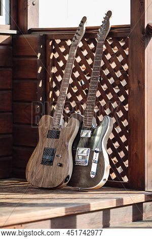 Electric Guitars Are Leaned Against A Wooden Stairs Outside On The Terrace