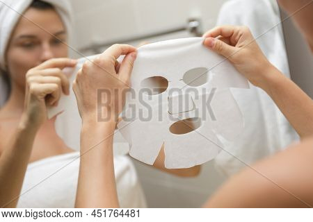 Woman In Bathroom Is Applying Facial Sheet Mask