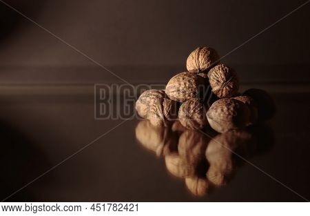 The Walnuts Heap Close-up. Copy Space. Beautiful Dark Background With Healthy Food. Ingredient. Usef