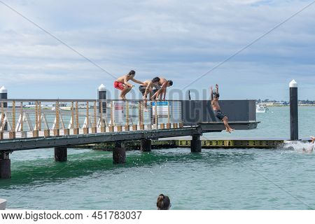Tauranga New Zealand March 26 2022;boys Enjoy Jumping Of Pier And Diving Platform On City Waterfront