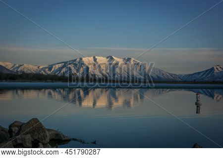 Mountain At Sunset Being Reflected In Lake Surface