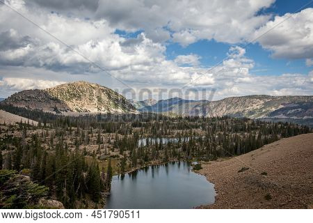 Mountain Valley With A Lake And Cloudy Sky