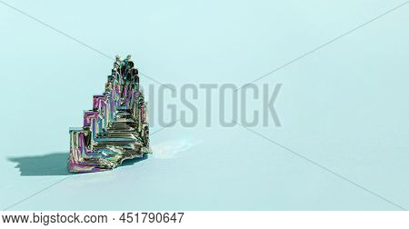 Synthetic Bismuth Bismuthum Crystal With Iridescent Oxide Film On Blue Background Close Up Isolated.