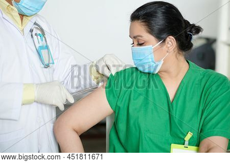 Medical Nurse Getting Second Shot Of Vaccine Against Coronavirus In Hospital
