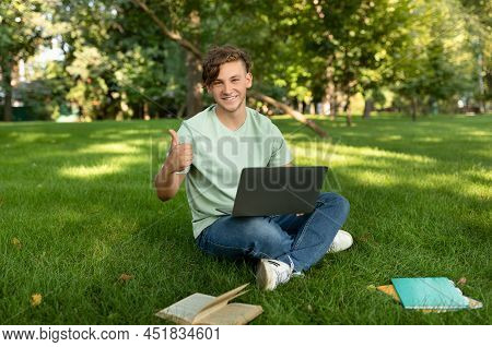 Happy Male Student Gesturing Like, Approving Educational Online Program, Sitting With Laptop In Park