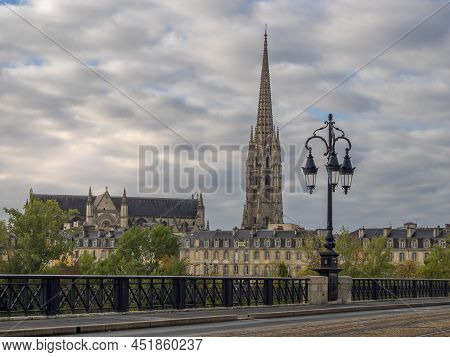 Stone Bridge On The Garonne River In Bordeaux With St Michel Cathedral, France.