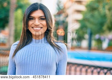 Beautiful hispanic woman smiling confient at the park