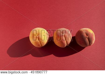 Three Fresh Ripe Peaches On A Red Background With Shadows, Horizontal Orientation With Copy Space.