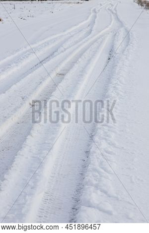 Snowy Road In A Field Leading To Pine Forest. Winter Road To Nowhere In Sunny Day, Snow-covered Fres