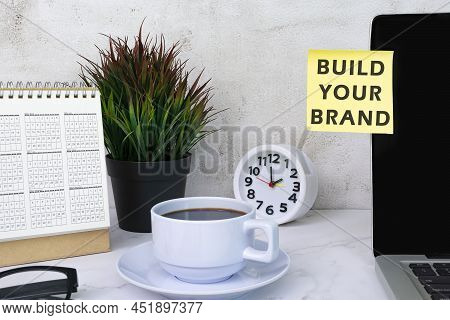 Build Your Brand Typed On Yellow Paper Stick On Top Of Computer Screen With Other Accessories.