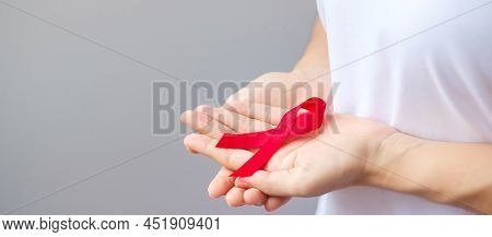 Hand Holding Red Ribbon For December World Aids Day (acquired Immune Deficiency Syndrome), Multiple 