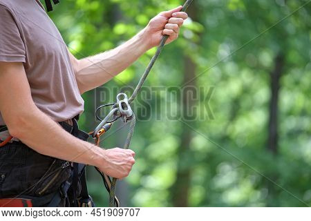 Man Belays His Partner Climber With Belaying Device And Rope. Climbers Handsman Holding Equipment Fo