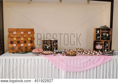 Candy Bar. Table With Different Sweets For Party. Wooden Wedding Decor. Different Candies, Cupcakes,
