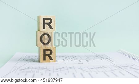 Three Wooden Cubes With Letters Ror, On White Table And Diagram, Business Concept. Ror - Short For R