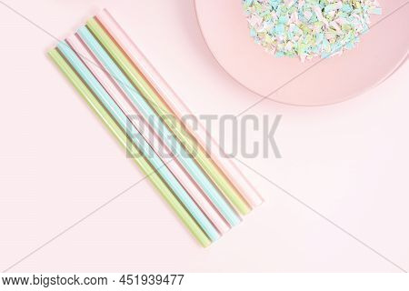 Drinking Straws And Plate Full Of Microplastics On A Pink Background. Impact Of Micro Plastic On The