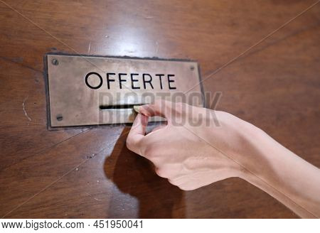 Hand Of Boy Putting A Coin Into The Offer Box With The Inscription Offerte The Means Offer In Italia