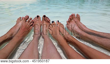 Eight Feet Of A Family Of Four While Relaxing In The Middle Of The Water In The Summer