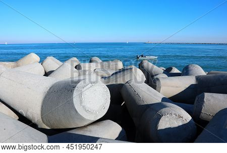 Wide Dam With Many Big Breakwater Also Called Groyne In Concrete And The Water Of The Sea