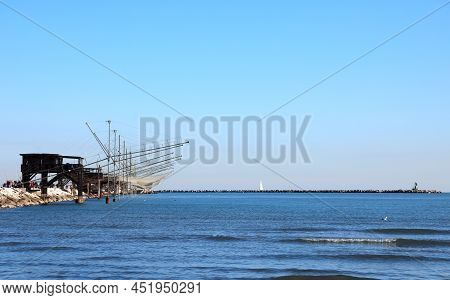 Many Fishing Huts On The Long Dike And Large Nets For Catching Fish And Crustaceans With The Blue Se