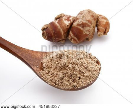 Fresh kencur roots and ground kencur powder on white background