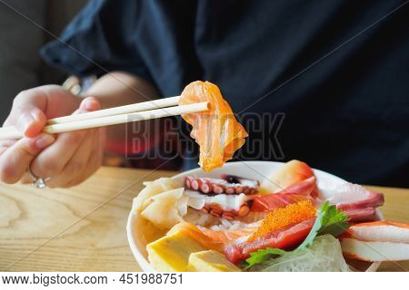 Salmon Slice In Chopsticks, Eating Sashimi Rice Bowl Chirashi Don Japanese Food