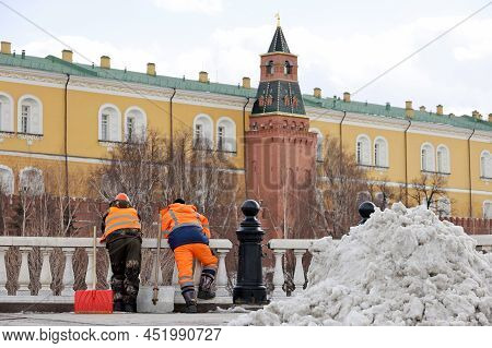 Two Workers With Shovels Standing On Moscow Kremlin Background. Labour Migrants During Rest, Street 