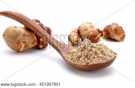 Fresh kencur roots and ground kencur powder on white background