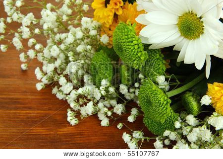Beautiful flowers on wooden background