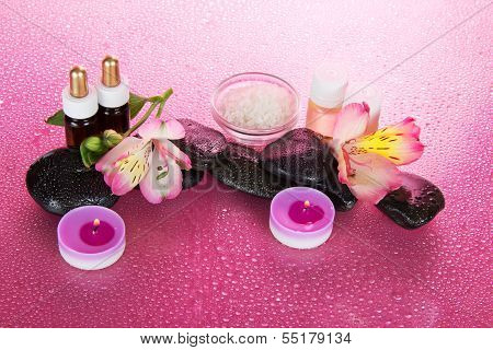 Set of fragrant oils, salt, candles, and flower