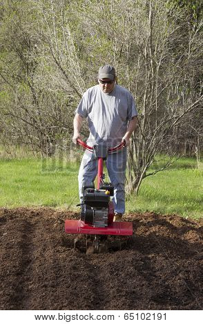Man Gardening With Rototiller