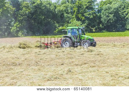 Tractor In Meadow Making Hay